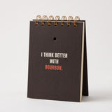 I Think Better With Bourbon notebook standing upright, showing the cream page edges