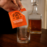 Pouring blood orange old fashioned mix into a rocks glass