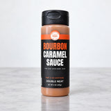 Double Neat Bourbon Caramel Sauce, 9 oz squeeze bottle on a marble counter