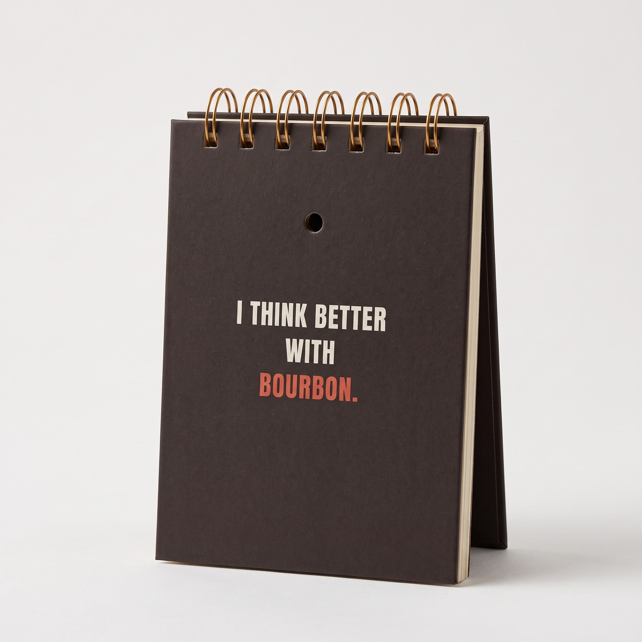 I Think Better With Bourbon notebook standing upright, showing the cream page edges