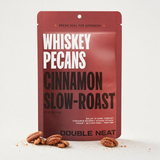 Double Neat Cinnamon Whiskey Pecans pouch with scattered glazed pecans on a neutral studio background